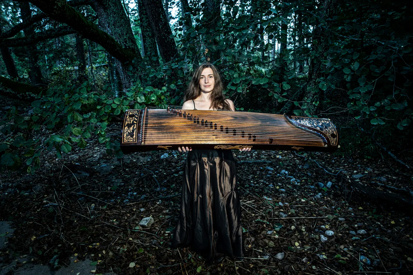 Barbora Xu with her guzheng among the trees